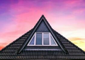 janela de telhado aberta em estilo velux com telhas pretas. foto