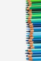 multicolorido lápis mentira em uma branco mesa, a verde alcance do cores foto