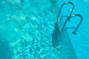 Escadaria dentro a natação piscina com azul água dentro a fundo foto