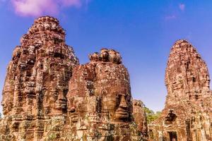 relevos de pedra nas torres do templo bayon em angkor thom foto