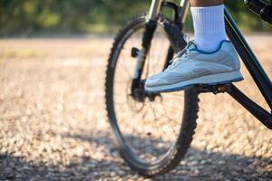 uma perspectiva baixa de ciclistas de montanha em um caminho rochoso com foco em sapatos foto