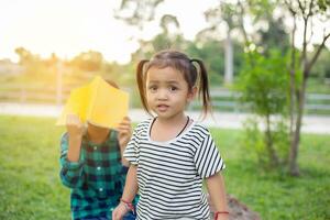 fofa pequeno menina lendo livro em árvore dentro park.sstkhome foto