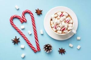 copo do quente chocolate com marshmallow cacau pó e caramelo em pastel azul fundo com cópia de espaço. Natal inverno conceito. foto