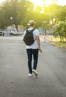 hipster cara caminhando em a rua, viajante cara caminhando dentro a cidade, atraente homem dentro chapéu caminhando em a rua foto