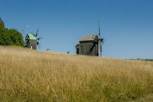 velho moinho de vento em azul céu fundo foto