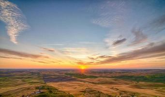 campos de palouse e fazendas na paisagem do pôr do sol em uma colina foto