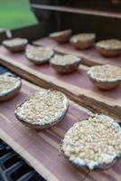 Grelhando cogumelos portobello em uma prancha de cedro foto