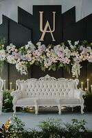 uma Casamento etapa com branco sofás e flores foto