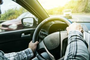 fechar acima do do homem mãos em a roda, uma pessoa dirigindo com mãos em a roda, uma homem com mãos em a roda do a carro, conceito do mãos em a roda do uma carro foto