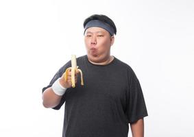 jovem asiático gordo comendo banana foto