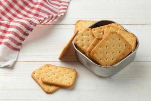 biscoitos cracker em uma tigela de aço inoxidável com toalha de mesa foto