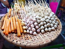 bolinhos de carne e salsichas fumegantes na bandeja de madeira foto