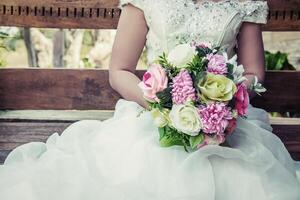 lindas cores diferentes nas mãos da noiva em um vestido branco foto