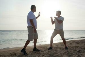 dois homens tendo boxe Treinamento em a de praia foto