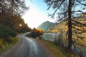 estrada de montanha isolada perto do lago no outono ao pôr do sol foto