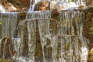 verão panorama com uma pequeno cascata e verde árvores foto