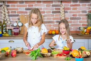 dois pequeno meninas dentro a cozinha com fresco legumes. saudável Comida conceito. feliz irmãs. foto