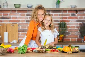 feliz mãe e filha estão tendo Diversão dentro a cozinha. saudável Comida conceito. foto