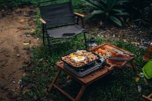 frito ovos e grelhado carne de porco dentro uma acampamento panela foto