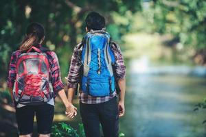 casal caminhando na floresta juntos. férias de viagens de aventura. foto
