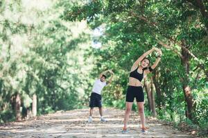 homem e mulher alongando-se juntos no parque. foto