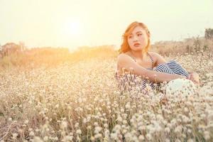 mulher triste sentada em um campo de flores e solidão foto