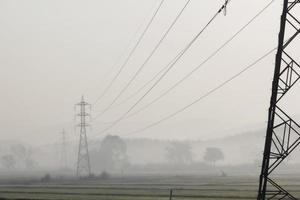 postes elétricos de alta tensão colocados no campo de arroz foto