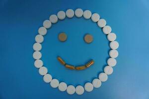 positivo sorrir fez do pílulas em azul fundo. conceito do medicamento, pílulas, tratamento, médico seguro. feliz conceito foto