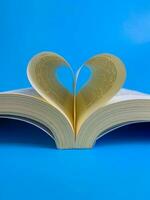 livro página dentro a forma do uma coração em uma azul fundo foto