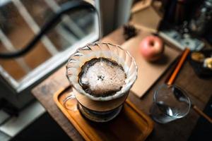 gotejar café em casa, derramar água quente sobre um gotejamento de café foto