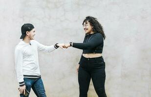 dois Adolescência amigos batendo seus punhos. uma cara e Adolescência menina tremendo punhos às cada outro, fechar acima do dois engraçado amigos batendo punhos dentro uma amigáveis caminho foto