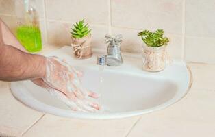 fechar acima do uma pessoa lavando seus mãos com sabão, conceito do corrigir mão lavando, maneiras para evita covid19 foto