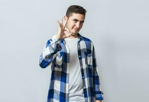 bonito cara gesticulando tudo é OK, pessoa fazer Está bem gesto isolado, sorridente homem mostrando Está bem gesto olhando às Câmera, conceito do expressão do tudo é multar. foto