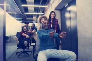 equipe de negócios multiétnica competindo em cadeiras de escritório foto