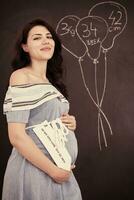 retrato de mulher grávida na frente de lousa preta foto