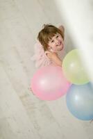 menina bonitinha brincando com balões foto