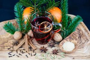 vinho quente e especiarias de natal em madeira de oliveira foto