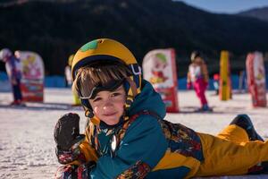 pequeno snowboarder deitado em a neve foto