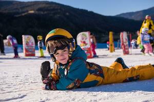 pequeno snowboarder deitado em a neve foto