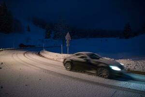 carro dirigindo em estrada perigosa à noite na neve foto
