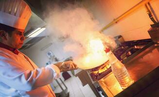 chef fazendo flambe na comida foto