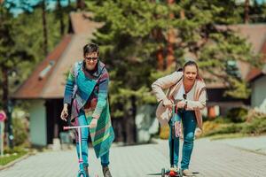 dois mulheres tendo Diversão dentro a parque enquanto equitação uma lambreta foto