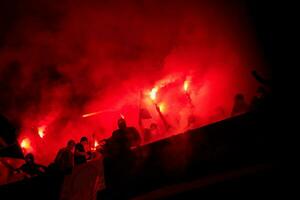 hooligans de futebol com máscara segurando tochas no fogo foto