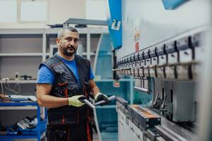 um operário ou engenheiro inteligente faz máquinas em uma oficina de produção. o conceito de indústria e engenharia. foco seletivo foto