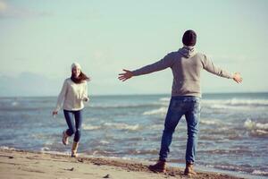 amando o jovem casal em uma praia em dia ensolarado de outono foto