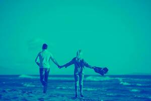 amando o jovem casal em uma praia em dia ensolarado de outono foto