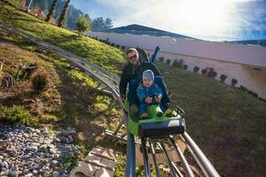 jovem pai e filho dirigindo alpino montanha-russa foto