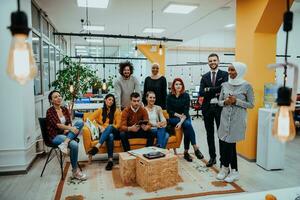 grupo do multiétnico colegas trabalhando em Área de Trabalho computadores, computador portátil e partilha seus Ideias dentro uma moderno escritório espaço.jovem influenciadores trabalhos em conectados marketing projetos. foto