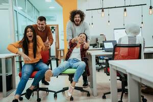 equipe construção e escritório Diversão. jovem alegre pessoas de negócio dentro inteligente casual vestem tendo Diversão enquanto corrida em escritório cadeiras e sorridente. foto