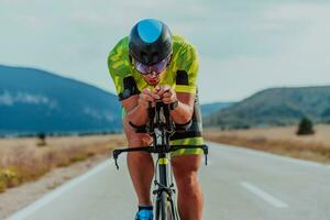 cheio comprimento retrato do a ativo triatleta dentro roupa de esporte e com uma protetora capacete equitação uma bicicleta. seletivo foco foto